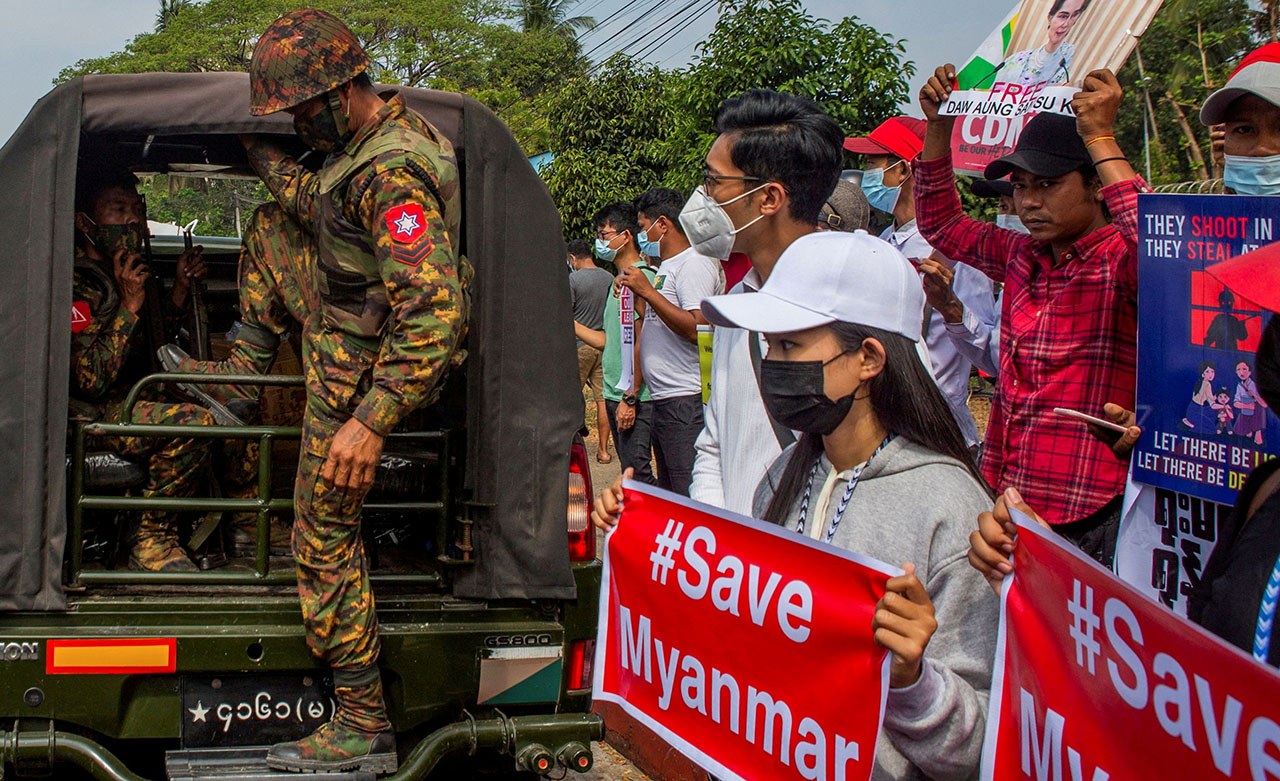 A soldier steps out of a military vehicle during a protest 