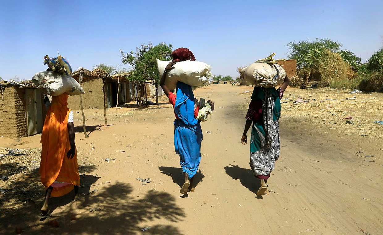 Internally displaced Sudanese women carry bags of farm products on their heads as they walk within the Kalma camp for internally displaced persons (IDPs) in Darfur, Sudan April 25, 2019