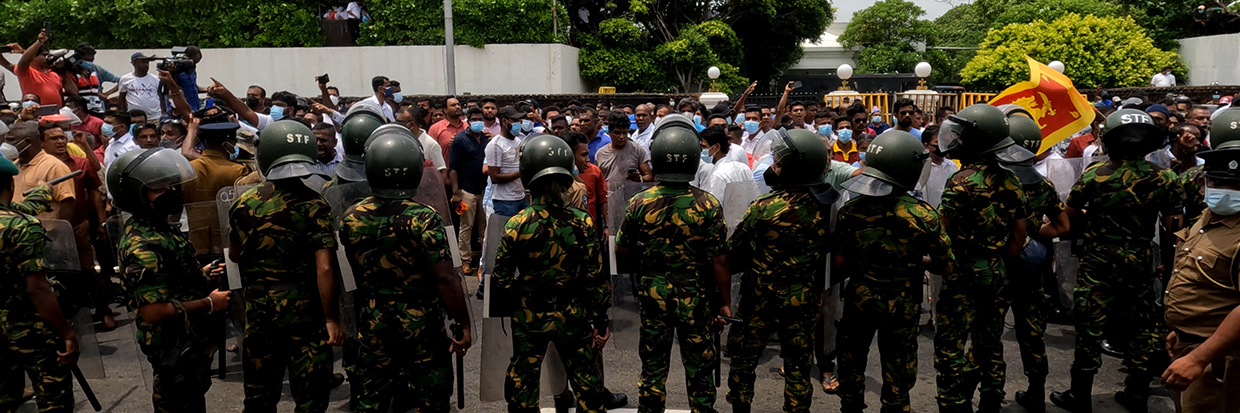 Manifestantes progubernamentales en Sri Lanka destruyen tiendas de manifestantes contra el gobierno a los que llaman ' Mainagogama' mientras agentes de policía observan frente a los árboles de los templos, Colombo, Sri Lanka.       9 de mayo de 2022 (Foto de Tharaka Basnayaka/NurPhoto)