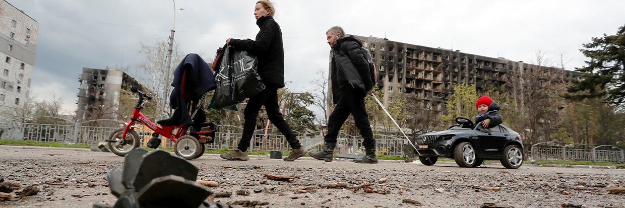 Family members are seen in a street near residential buildings damaged during Ukraine-Russia conflict in the southern port city of Mariupol, Ukraine April 22, 2022