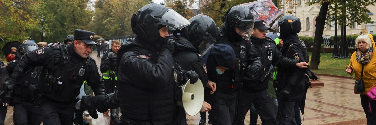 Des membres des forces de l’ordre appréhendent une personne durant une manifestation à Moscou, en Fédération de Russie, le 24 septembre 2022. © REUTERS