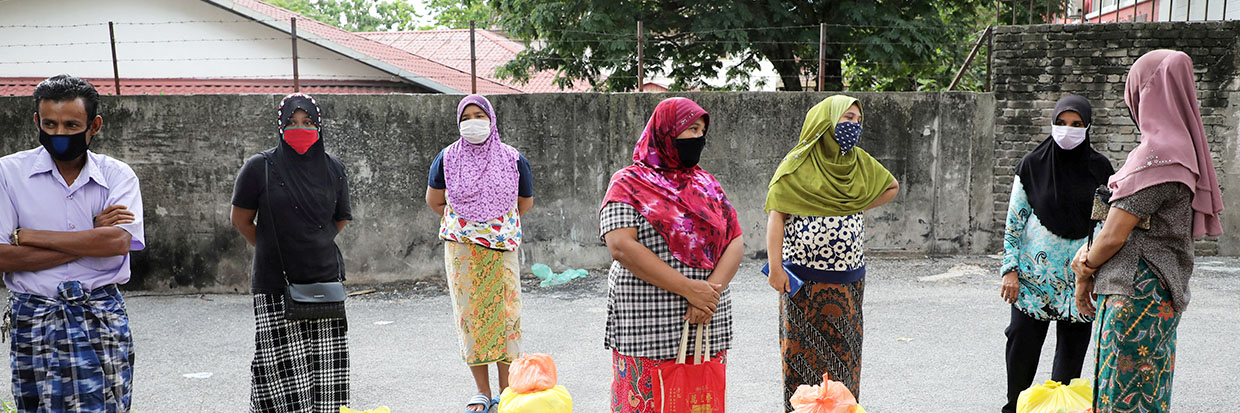 Refugiados y refugiadas Rohingya con máscaras protectoras mantienen la distancia social mientras esperan a recibir productos de voluntarios, durante la orden de control de movimientos como resultado de la aparición de la enfermedad de coronavirus (COVID-19), en Kuala Lumpur, Malasia, 7 de abril de 2020. REUTERS/Lim Huey Teng/Fotografía de Archivo/Fotografía de Archivo