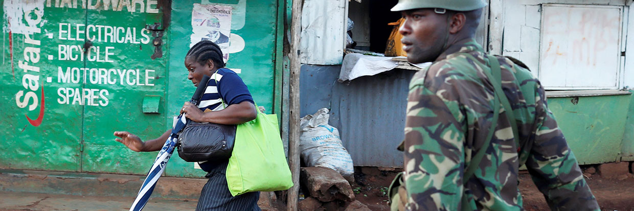 Una mujer corre delante de un policía durante  choques entre partidarios de la oposición y la policía en el suburbio de  Kawangware en Nairobi, Kenya, 30 de octubre de 2017. © REUTERS/Goran Tomasevic