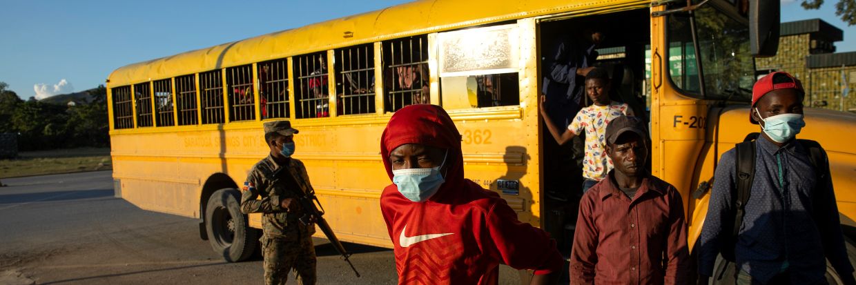 Un militaire de la République dominicaine surveille un bus de la Direction nationale des migrations servant à transporter 52 migrants haïtiens expulsés par le poste-frontière de Comendador, en République dominicaine, le 22 novembre 2021. Photo : EPA-EFE/Orlando Barria