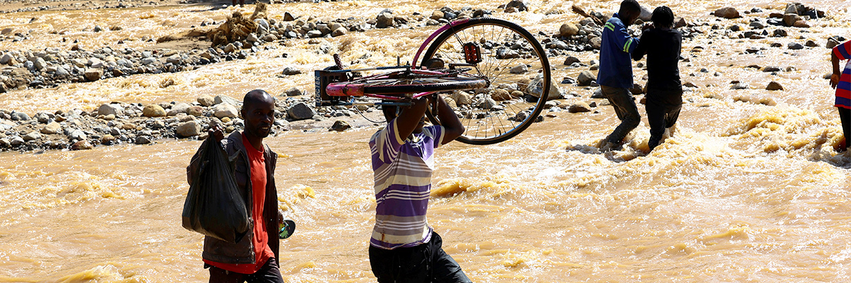 Des habitants traversent une zone inondée à Muloza, à la frontière avec le Mozambique, après le passage du cyclone tropical Freddy à une centaine de kilomètres de Blantyre, au Malawi, le 18 mars 2023. © REUTERS/Esa Alexander