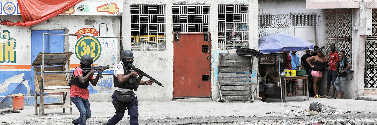 Personas se concentran en una esquina a la vez que la policía patrulla las calles después de que miembros de bandas intentaran atacar una comisaría de policía, en Puerto Príncipe, Haití, 25 de abril de 2023. ©REUTERS/Ralph Tedy Erol TPX IMAGES OF THE DAY 