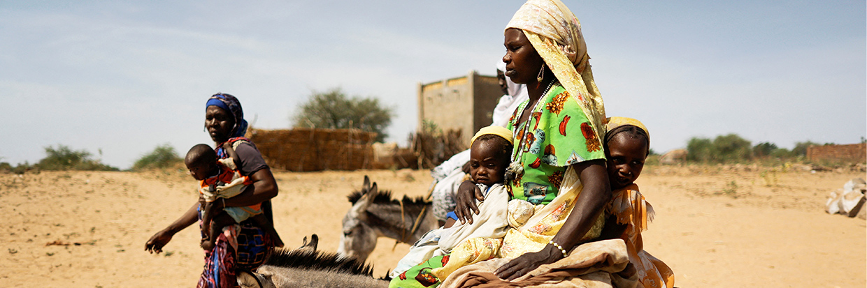 حواء آدم، لاجئة سودانية فرت من العنف الدائر في منطقة دارفور السودانية، تركب حمارًا مع طفليها وهي تتجه إلى نبع مياه بالقرب من الحدود بين السودان وتشاد في غونغور، تشاد، 8 أيار/ مايو، 2023. رويترز/ زهرة بنسمرا