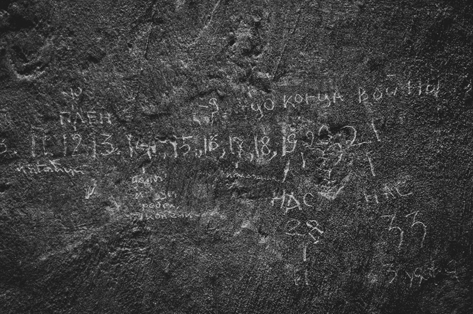 Inscriptions made by detained civilians on a wall of a makeshift detention place in Dymer, Kyiv region. © OHCHR