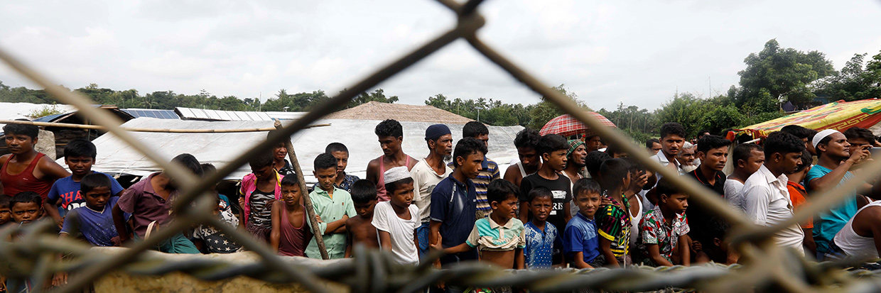 Refugiados y refugiadas Rohingya reunidos cerca de la valla en la zona de “tierra de nadie” entre la frontera de Bangladesh y Myanmar en el distrito de Maungdaw, Estado de Rakhine, zona occidental de Myanmar, 24 de agosto de 2018. Ⓒ EPA-EFE/NYEIN CHAN NAING.