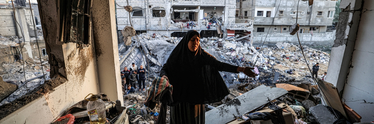 A woman inspects the destroyed building of Palestinian journalist Adel Zorob, who was killed overnight in an Israeli bombardment, in Rafah in the southern Gaza Strip on December 19, 2023. © Mahmud HAMS / AFP