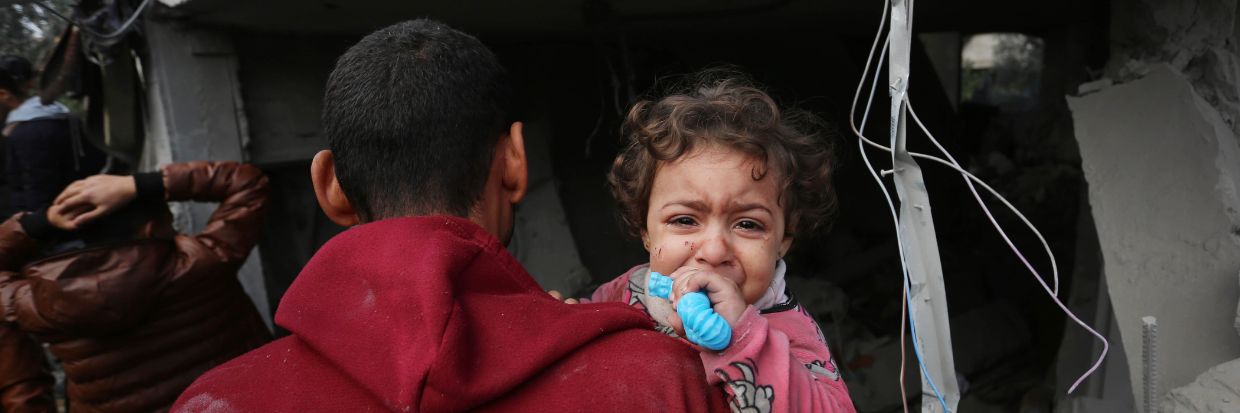 Maghazi, Gaza – 25 décembre : un homme tient un enfant en pleurs alors que les efforts de recherche et de sauvetage des personnes sous les décombres se poursuivent après une frappe aérienne israélienne sur une zone résidentielle civile dans le camp de réfugiés d’Al-Maghazi, à Gaza, le 25 décembre 2023. © ASHRAF AMRA/ANADOLUNO