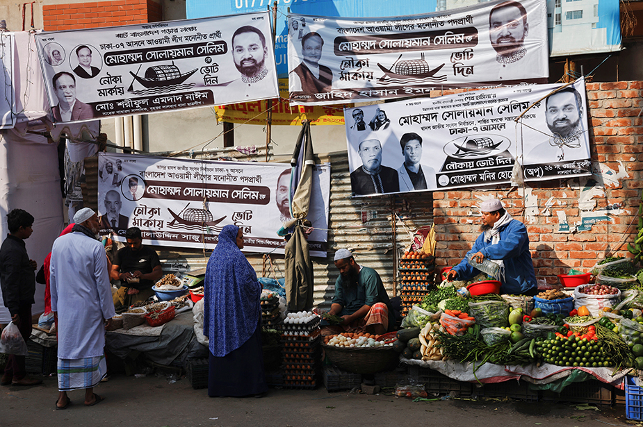 Electoral banners hang on walls as street vendors sell vegetables in Dhaka ahead of the general election in Bangladesh. © REUTERS/Mohammad Ponir Hossain