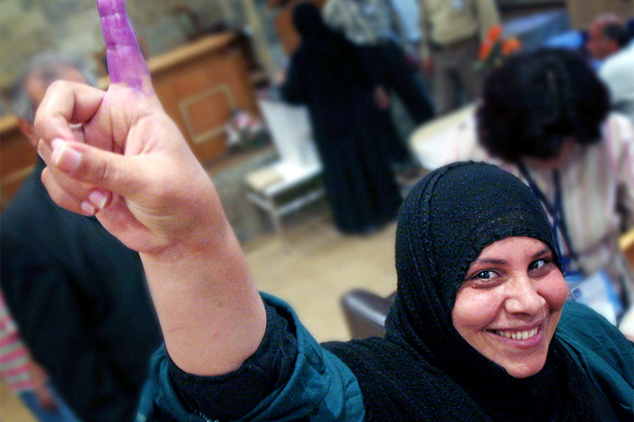 A woman shows her ink-stained finger after voting in a constitutional referendum in Baghdad in 2005. ©REUTERS/Thaier Al-Sudani