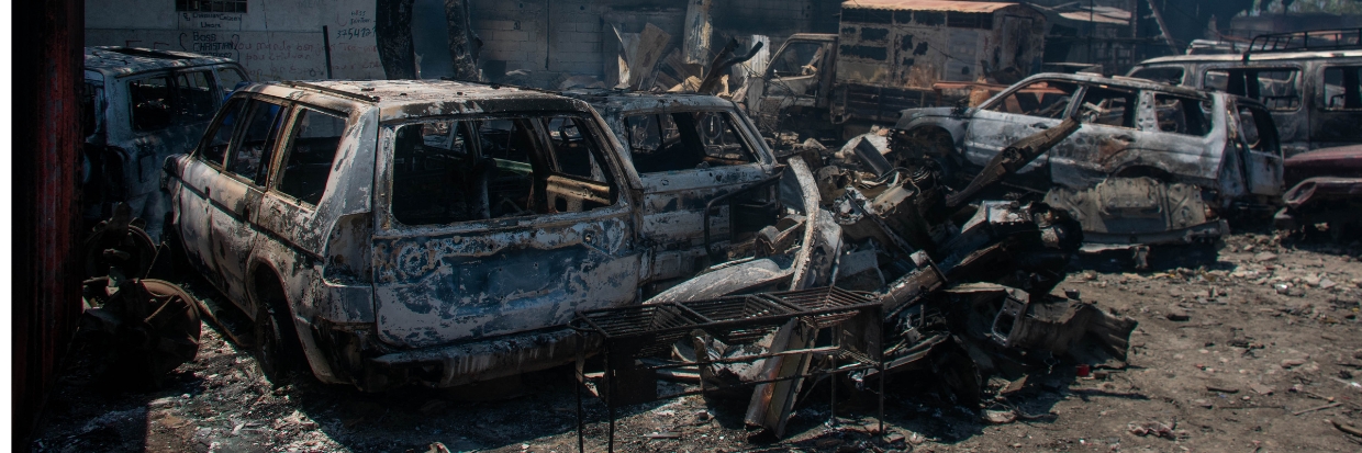 Restos calcinados de vehículos que fueron incendiados cerca de un garaje yacen en Puerto Príncipe, (Haití), el 25 de marzo de 2024. © Clarens SIFFROY / AFP 