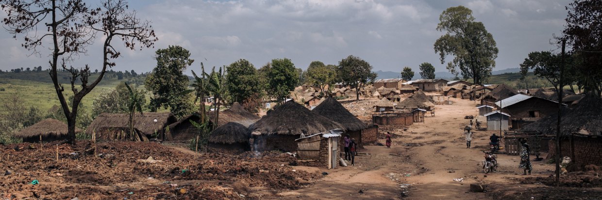 Varias personas buscan en las ruinas del campo de desplazados internos de Drodro el 18 de diciembre de 2021, a 60 kilómetros de Bunia, la capital provincial de Ituri, en el noreste de la República Democrática del Congo. © ALEXIS HUGUET / AFP