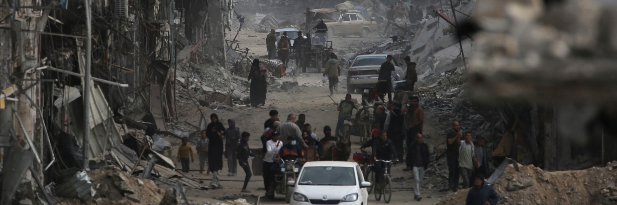 Palestinians walk past damaged buildings in Khan Yunis on April 8, 2024 after Israel pulled its ground forces out of the southern Gaza Strip, six months into the devastating war sparked by the October 7 attacks. Photo by AFP