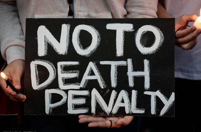 Filipino students’ light candles and hold a placard during a protest against the death penalty in Manila, Philippines. © EPA/MARK R. CRISTINO