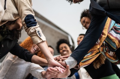 Group of people with stacked hands. © FG Trade / Getty Images