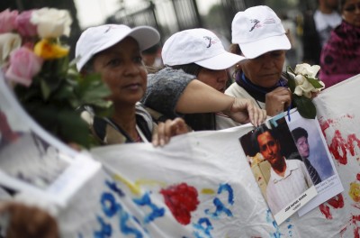 Women of the Caravana de Madres Centroamericanas (Caravan of Central American Mothers) hold up photos of missing migrants. © REUTERS/Edgard Garrid