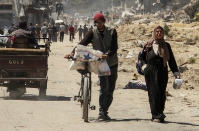 Palestinians carry aid as others struggle to receive their portion amid a widespread hunger, as the conflict between Israel and the Palestinian Islamist group Hamas continues, in Gaza City April 3, 2024. © REUTERS/Mahmoud Issa