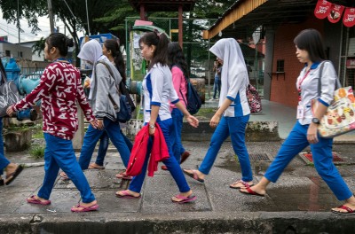 A group of young women migrant workers make their way through back alleys to get to work at a nearby hi-tech factory facility, Petaling Jaya, Malaysia, 28 November 2017. © UN Women