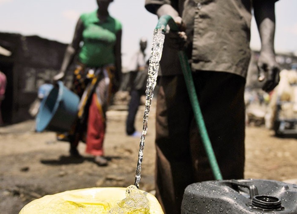 水贩用水桶装水，在玛萨瑞（Mathare）贫民区售卖，肯尼亚内罗毕，2012年3月22日。 法新社图片/Tony KARUMBA