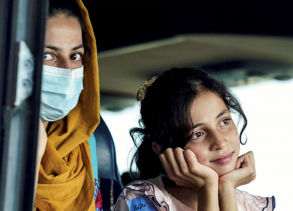 A mother wearing a mask with her daughter