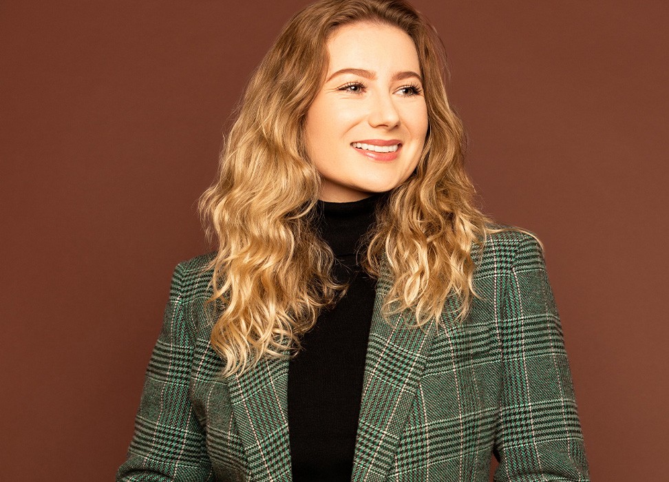 White woman with blonde hair smiles wearing green jacket over a black turtleneck © 2015 Steve LLamb & Images Burnside/Keely Cat-Wells/C Talent