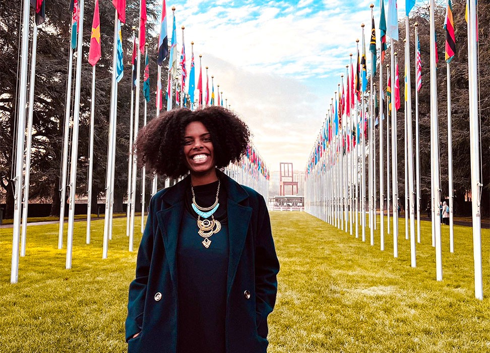 Monique Rodrigues do Prado devant l’œuvre Broken Chair et les drapeaux du Palais des Nations, au Siège des Nations Unies à Genève, en décembre 2022 © Monique Rodrigues do Prado