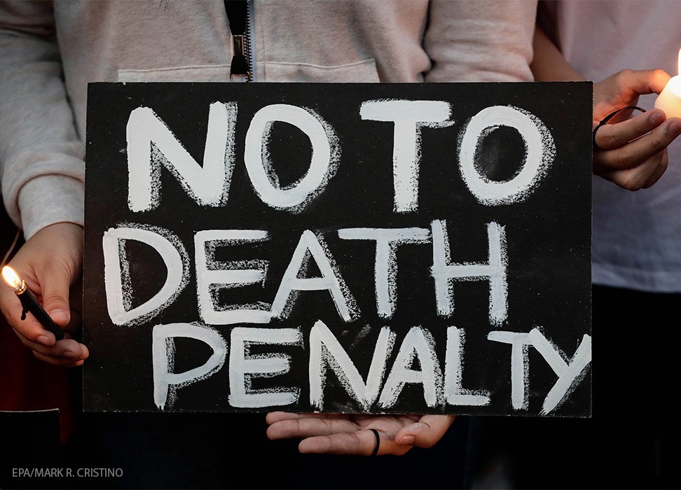 Estudiantes filipinos encienden velas y sostienen una pancarta durante una protesta contra la pena de muerte en Manila, Filipinas. © EPA/MARK R. CRISTINO