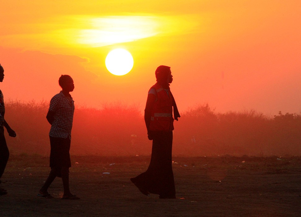 Des personnes ayant fui les combats au Soudan du Sud marchent au coucher du soleil à leur arrivée dans un camp de réfugiés © REUTERS/James Akena