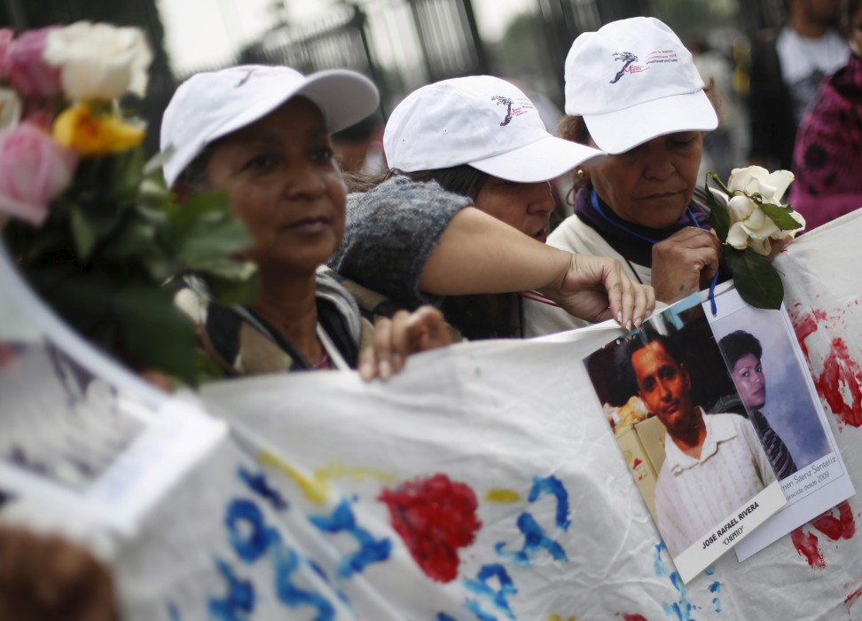 Women of the Caravana de Madres Centroamericanas (Caravan of Central American Mothers) hold up photos of missing migrants. © REUTERS/Edgard Garrid