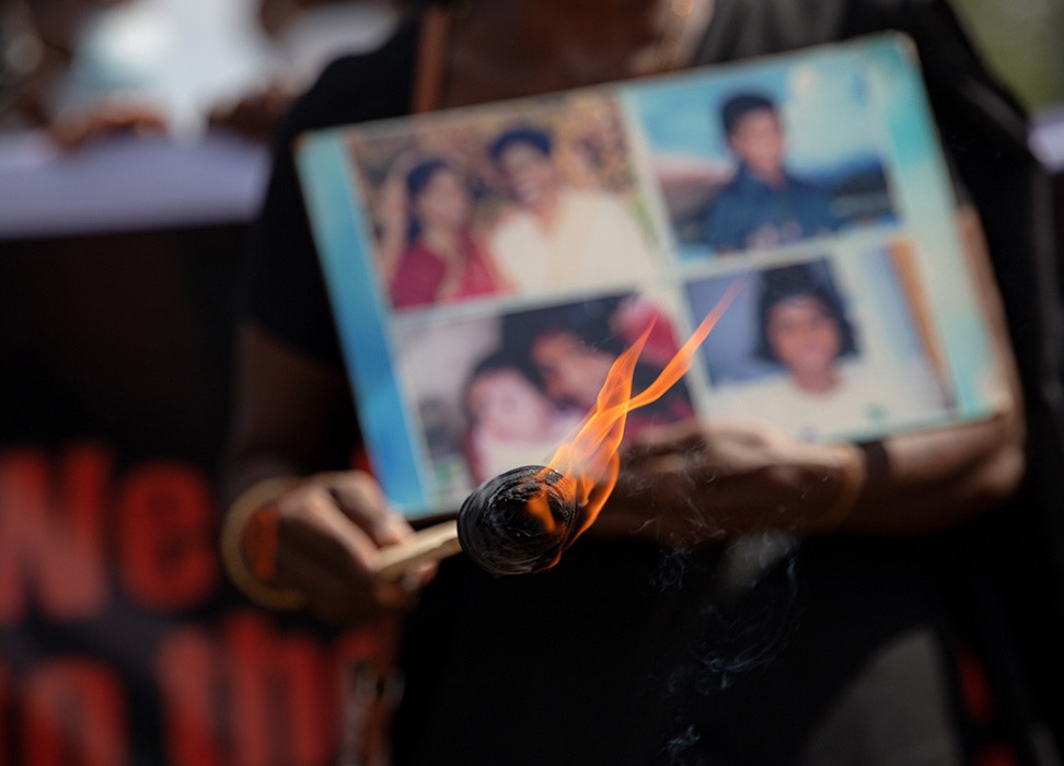 Familiares de personas desaparecidas sostienen fotografías de sus seres queridos durante una manifestación. © Kumanan Kanapathippillai