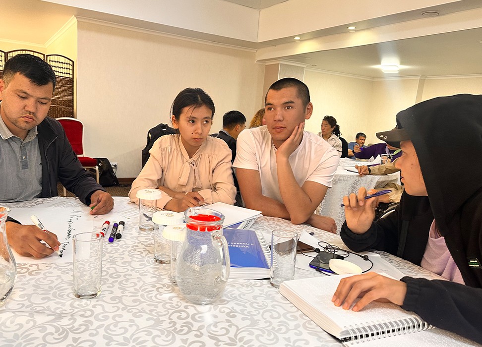 Four young people sitting around a table in a conference