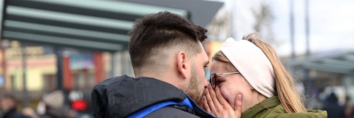 زوجان أوكرانيان يتعانقان في أحد الشوارع بعد أن قررا مغادرة لفيف في غرب أوكرانيا والتوجّه إلى بولندا المجاورة لإخلاء المدينة، في 24 شباط/ فبراير 2022. © كونيهيكو ميورا/ The Yomiuri Shimbun عبر Reuters Connect