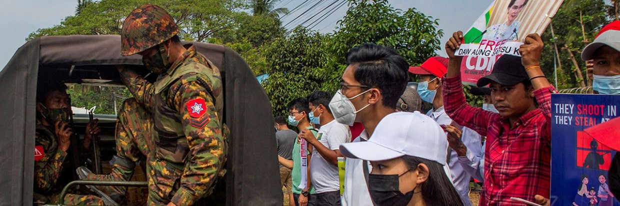 A soldier steps out of a military vehicle during a protest 