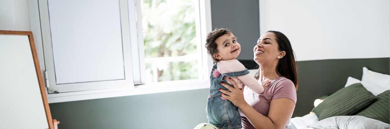 Mother with disability playing with baby girl at home © Getty Images