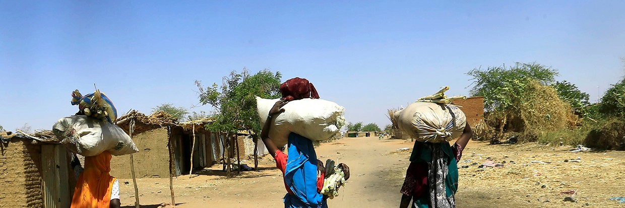 Internally displaced Sudanese women carry bags of farm products on their heads as they walk within the Kalma camp for internally displaced persons (IDPs) in Darfur, Sudan April 25, 2019