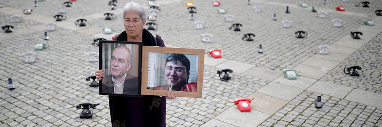 Fadwa Mahmoud brandit les portraits de son fils et de son mari, disparus en 2012, au milieu de 300 téléphones placés par terre par des familles syriennes sur la Bebelplatz de Berlin, en Allemagne, pour demander aux gouvernements de redoubler d’efforts afin d’obtenir des informations sur les personnes détenues en Syrie, le 28 août 2021. REUTERS/Hannibal Hanschke