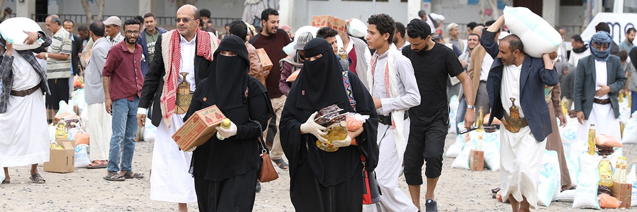 People carry food items they received from the local charity, Mona Relief, in Sanaa, Yemen April 24, 2022. © REUTERS/Khaled Abdullah