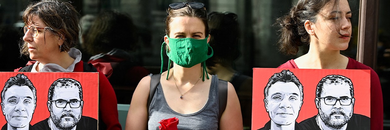 Plusieurs manifestants tiennent des pancartes et des roses en guide de protestation à la suite de la disparition en Amazonie du journaliste Dom Phillips et du défenseur des droits autochtones Bruno Araújo Pereira, devant l’Ambassade du Brésil à Londres, le 9 juin 2022.