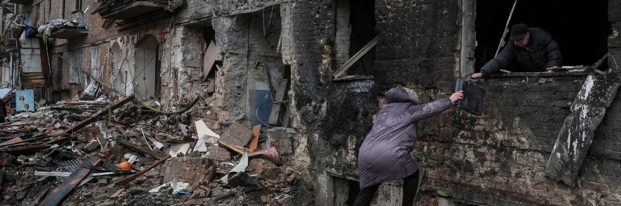 Des habitants récupèrent des affaires dans leur immeuble détruit par une attaque de missiles russes, alors que l’attaque de la Fédération de Russie contre l’Ukraine se poursuit, dans la ville de Vyshhorod, près de Kyïv, le 24 novembre 2022. Ⓒ REUTERS/Gleb Garanich