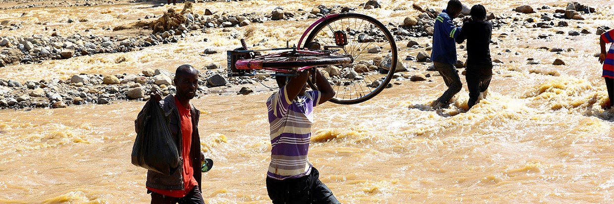 Residentes cruzan una zona inundada en Muloza en la frontera con Mozambique tras el paso del ciclón tropical Freddy, a aproximadamente 100 km a las afueras de Blantyre, Malawi, 18 de marzo de 2023. © REUTERS/Esa Alexander