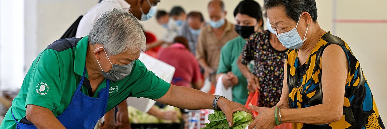 Des bénévoles distribuent aux habitants du quartier des produits récupérés par la communauté Fridge Restock, à Singapour, le 29 mars 2023. Plus de 800 000 tonnes de déchets alimentaires ont été générées à Singapour en 2021, une quantité qui a augmenté de 20 % ces dix dernières années et qui représente désormais 12 % de tous les déchets générés à Singapour, selon l’Agence nationale de l’environnement de Singapour. Ⓒ REUTERS/Caroline Chia