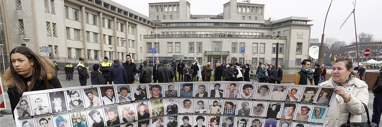 Des survivants bosniaques et des membres de leur famille portent une banderole où figurent des victimes de la guerre de Bosnie lors d’un rassemblement devant le Tribunal pénal international pour l’ex-Yougoslavie avant l’annonce du verdict du procès pour génocide de l’ancien dirigeant serbe de Bosnie Radovan Karadzic, à La Haye, aux Pays-Bas, le 24 mars 2016. © REUTERS/Michael Kooren