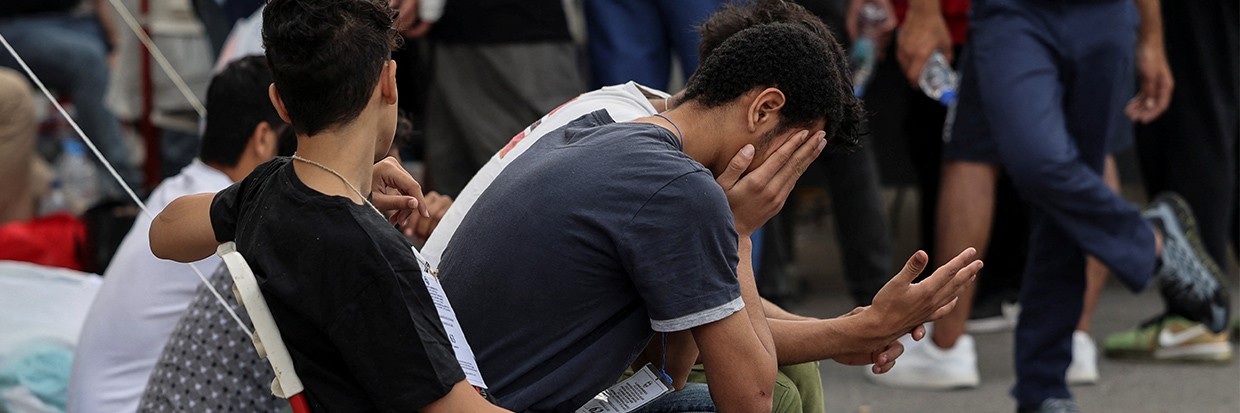 Migrants, survivors of a deadly shipwreck after a boat capsized at open sea off Greece, wait to board a bus as they are being transferred to Athens from the port of Kalamata, Greece, June 16, 2023 © REUTERS/Stelios Misinas