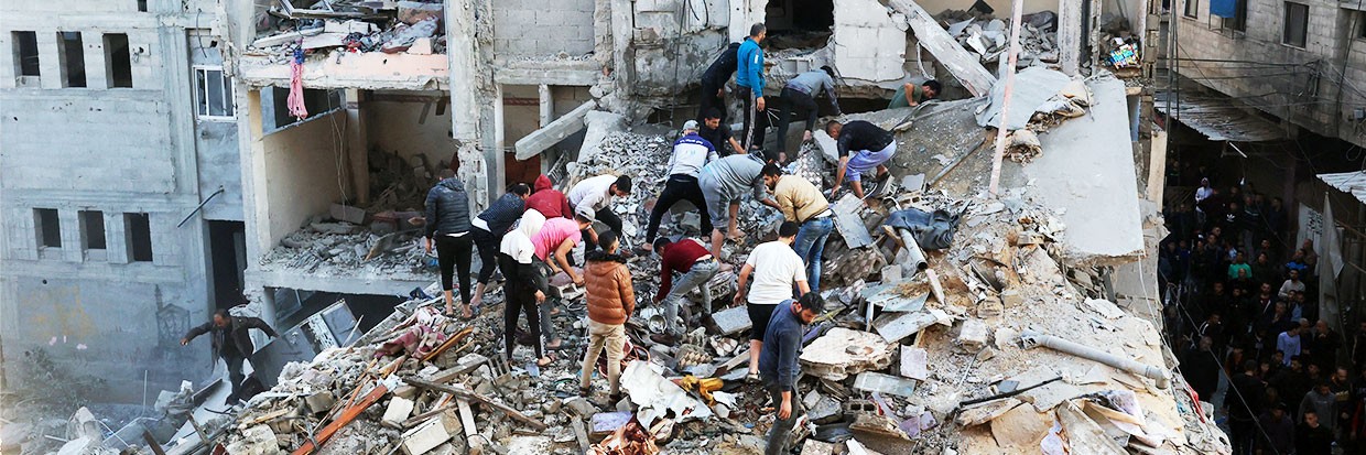 Personas palestinas inspeccionan los daños cercanos a edificios residenciales tras los ataques aéreos por parte de Israel en el campamento de refugiados de Rafah en el sur de la Franja de Gaza, el 1 de diciembre de 2023, tras la reanudación de los combates poco después de que expirara la tregua de siete días entre Israel y militantes de Hamas.© Photo by SAID KHATIB / AFP