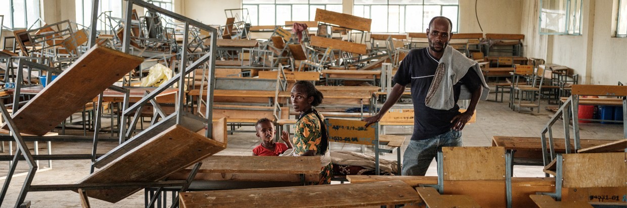 Una familia recién llegada, que huyó de la violencia en la región de Tigray de Etiopía, sentada en una antigua aula de la escuela secundaria de May Weyni, la cual alberga ahora a 10.500 personas desplazadas en su nueva función como campamento de desplazados internos, en Mekele, la capital de la región de Tigray, Etiopía, el 19 de junio de 2021. © Yasuyoshi CHIBA / AFP