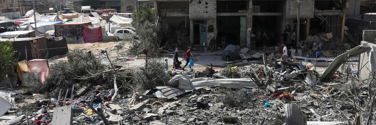 People walk among debris, aftermath of Israeli strikes at the area, where Israeli hostages were rescued on Saturday, as Palestinian death toll rises to 274, amid the Israel-Hamas conflict, in Nuseirat refugee camp in the central Gaza Strip, June 9, 2024. © REUTERS/Abed Khaled