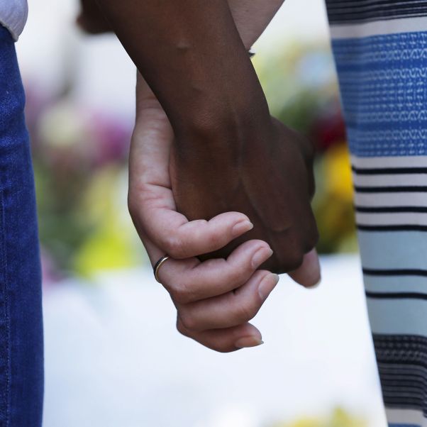 Mourners hold hands outside the Emanuel African Methodist Episcopal Church in Charleston, South Carolina, June 18, 2015 a day after a mass shooting left nine dead. © REUTERS/Brian Snyder